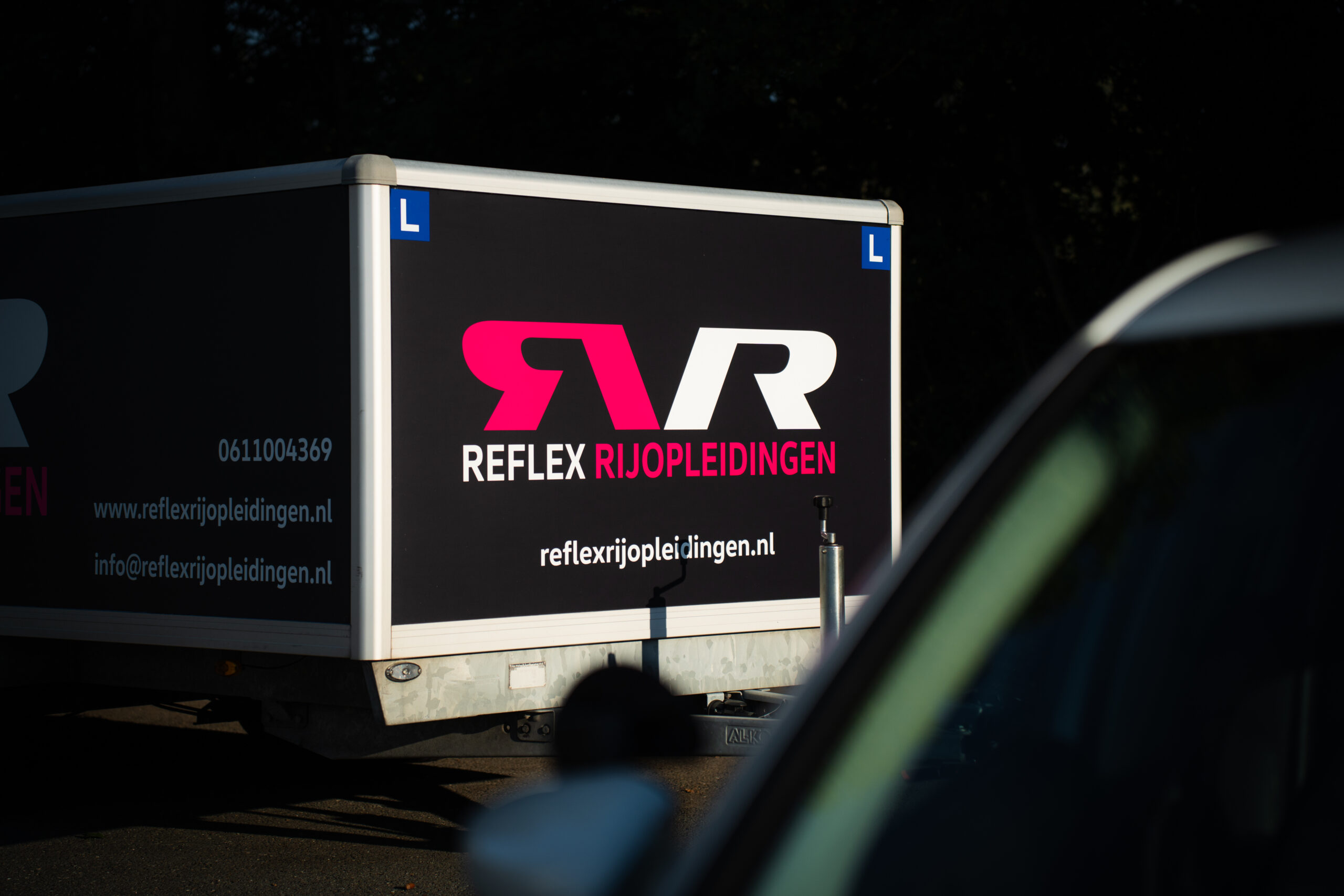 Aanhanger van Reflex Rijopleidingen, klaar voor rijlessen.